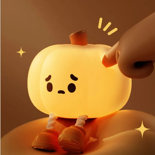 Halloween Pumpkin Silicone Night Light — close-up of glowing pumpkin with cute sad face being tapped by a hand, showing tap control with little legs and orange shoes
