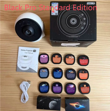 Galaxy Star Projector Light — flat lay of Black Pro Standard Edition showing white projector, product box, user manual, 12 film discs, USB cable, and accessory boxes on a wooden surface