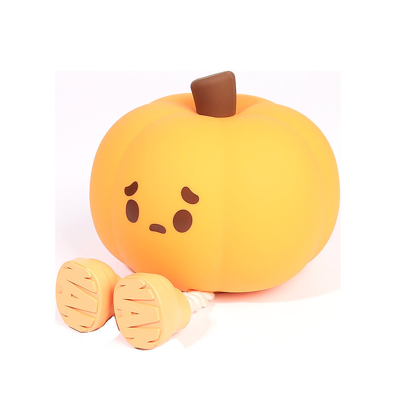 Halloween Pumpkin Silicone Night Light — cute pumpkin silicone lamp with sad face, brown stem, and little legs with beige shoes on a white background